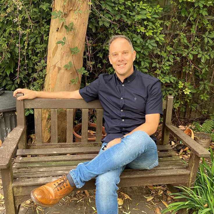 A man sitting on a bench with his legs crossed