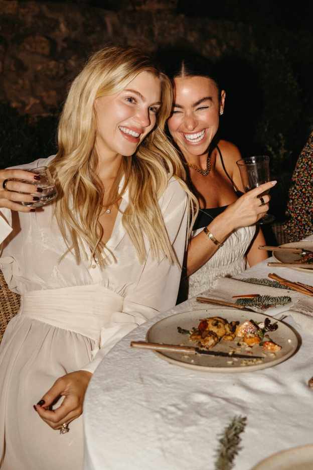 Friends at holiday backyard dinner party around table at night