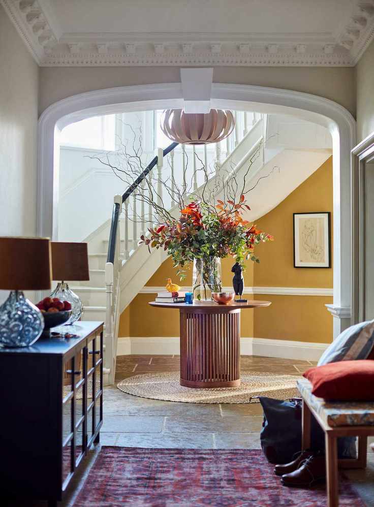 A grand hallway with yellow paint and a circular table