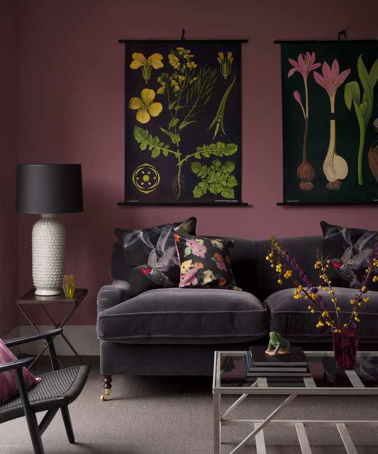 A dark purple painted room with dark purple and grey living room furniture.
