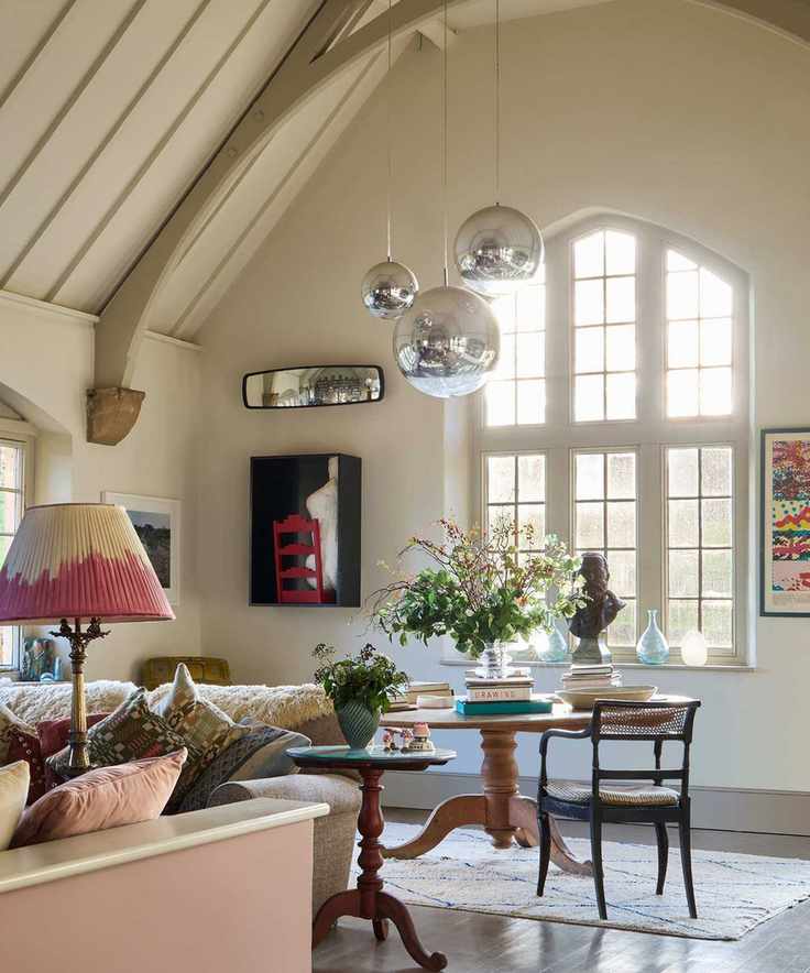 A large room with off white walls and large silver pendant lights