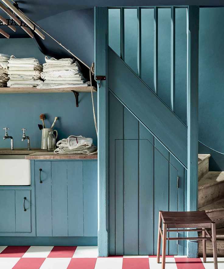 Kitchen color drenched in light blue paint, paired with a red and white chequered floor
