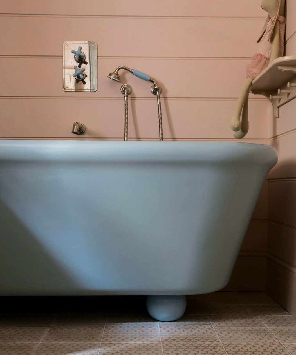 Blue bathroom with pink panel walls and blue bathtub