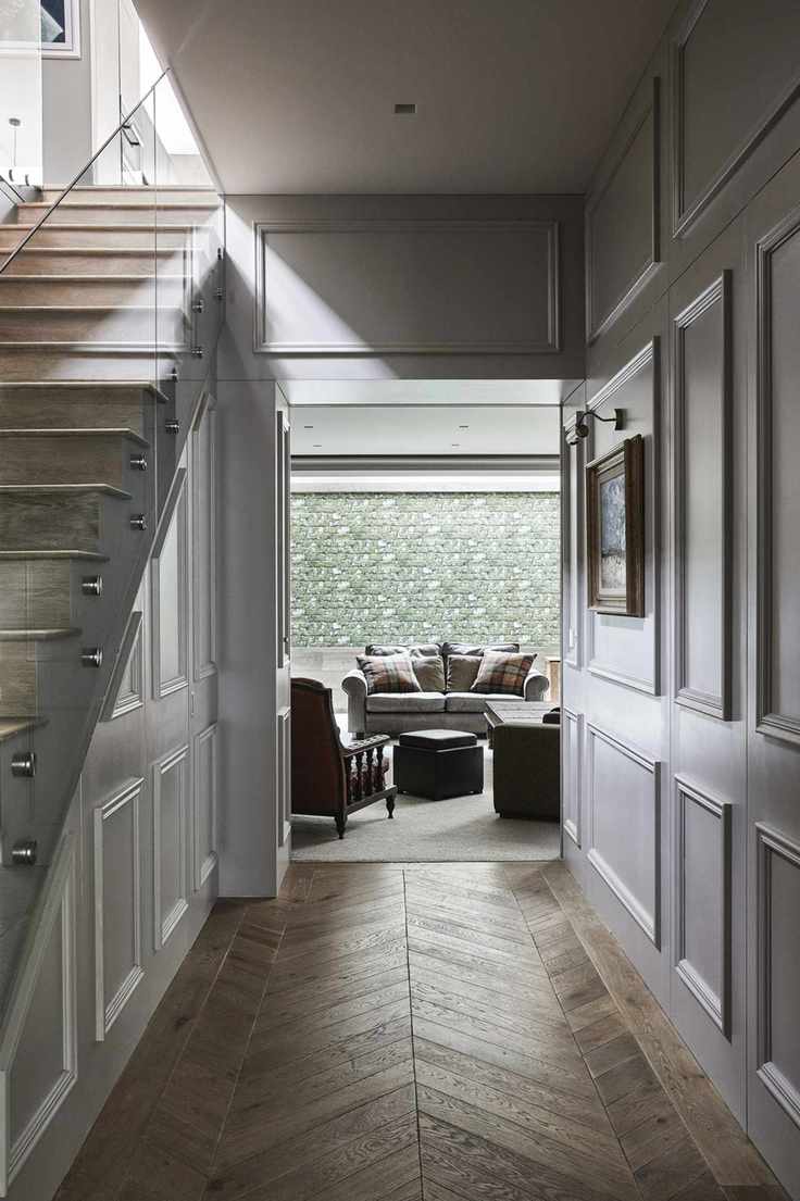 Hallway with elegant paneling and modern staircase