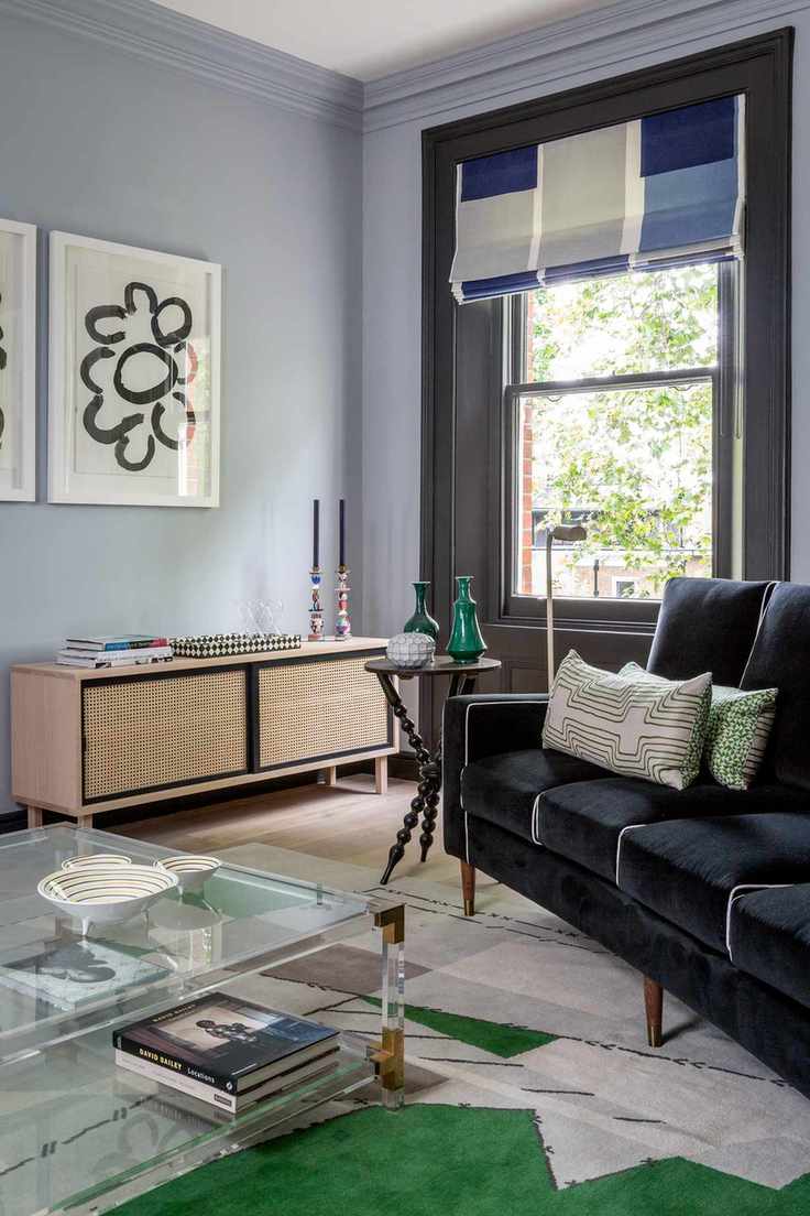 Living room with sofa, coffee table, sideboard, rug and Roman blind
