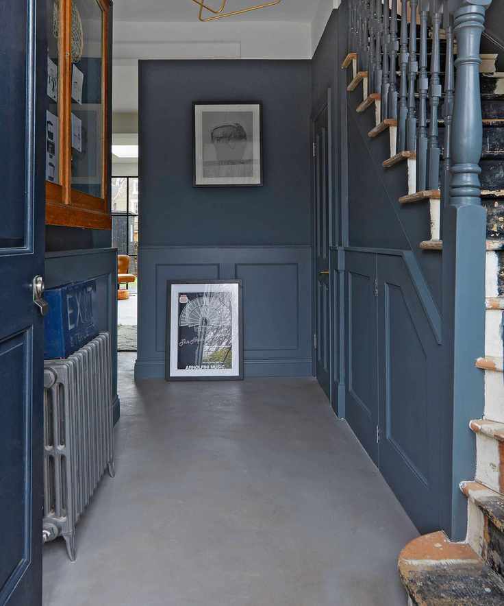 Stylish hallway with blue walls and concrete flooring