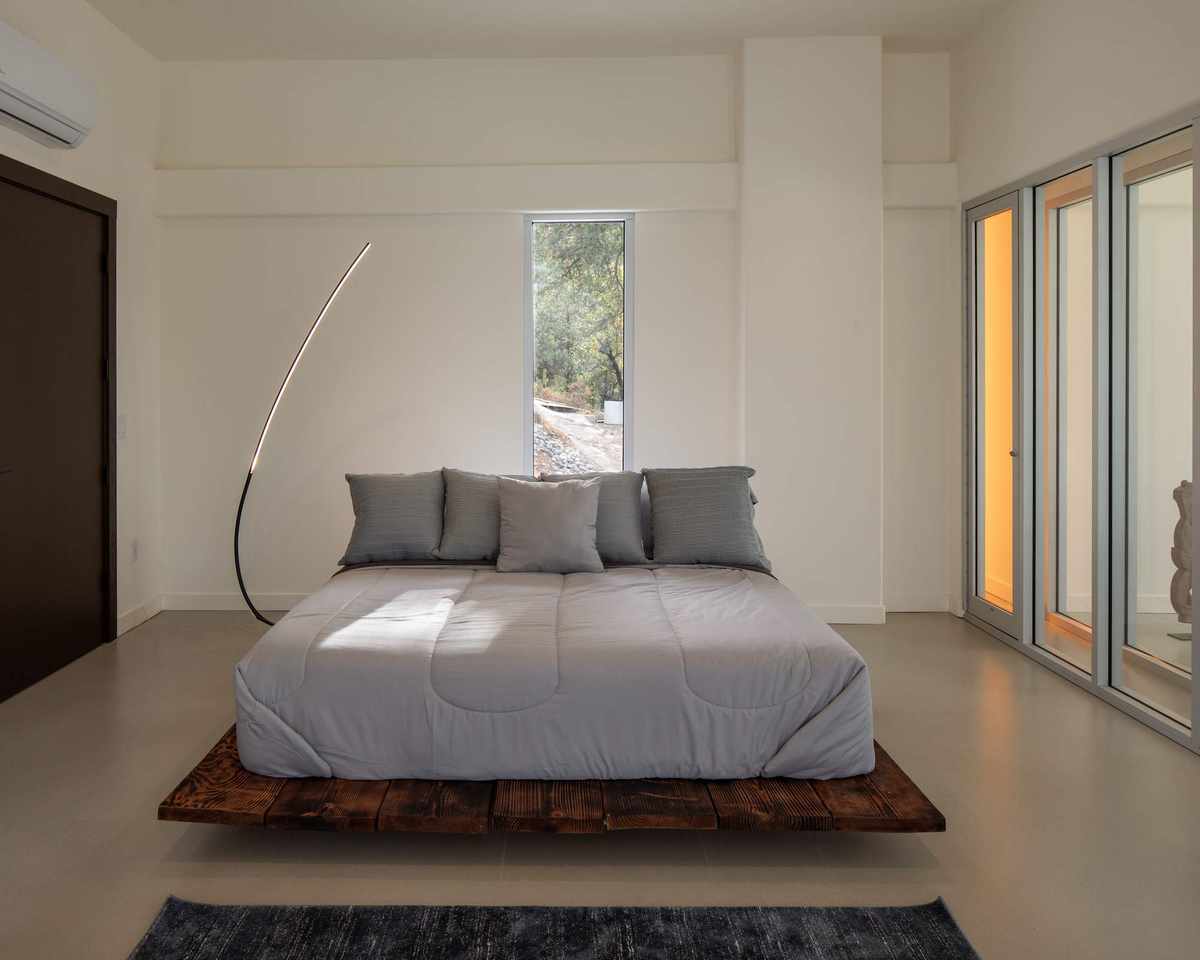 Brutalist bedroom featuring concrete details and wood accents