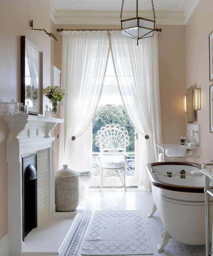 sheer window curtains in a vintage traditional bathroom with claw foot bathtub