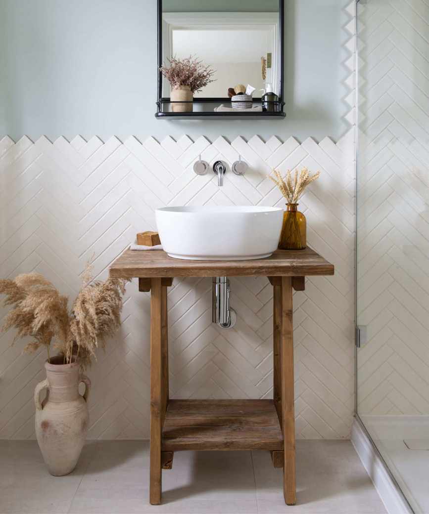 A small bathroom with a wooden vanity featuring open storage