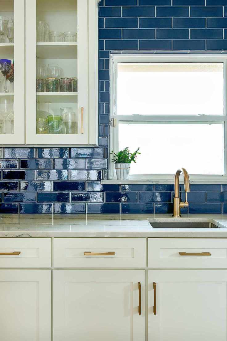 Kitchen with white cabinets and blue subway tile backsplash