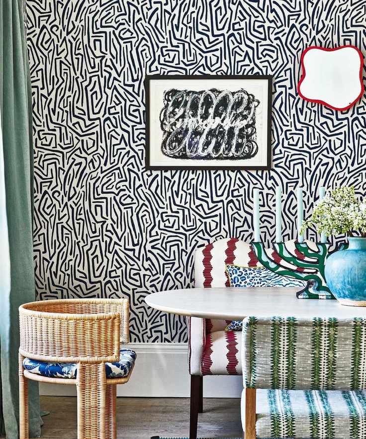 maximalist dining room with abstract, monochrome wallpaper, contrasting textured dining chairs