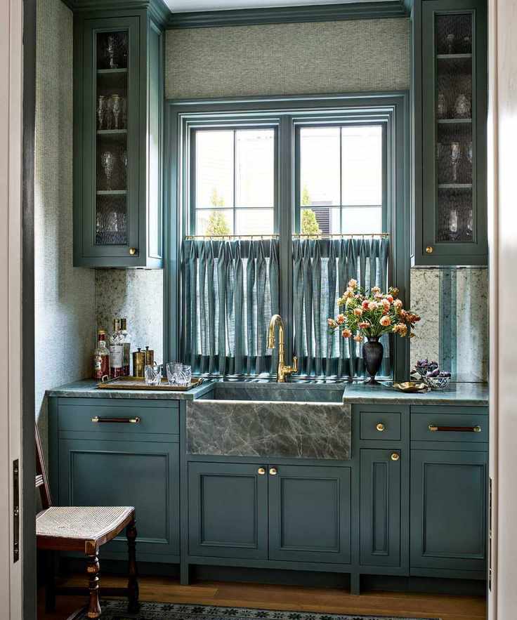 Blue home bar with a marble sink and glassware storage