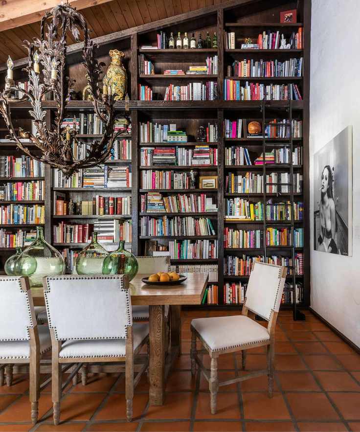 Dining space with tall bookshelves filled with cookbooks.