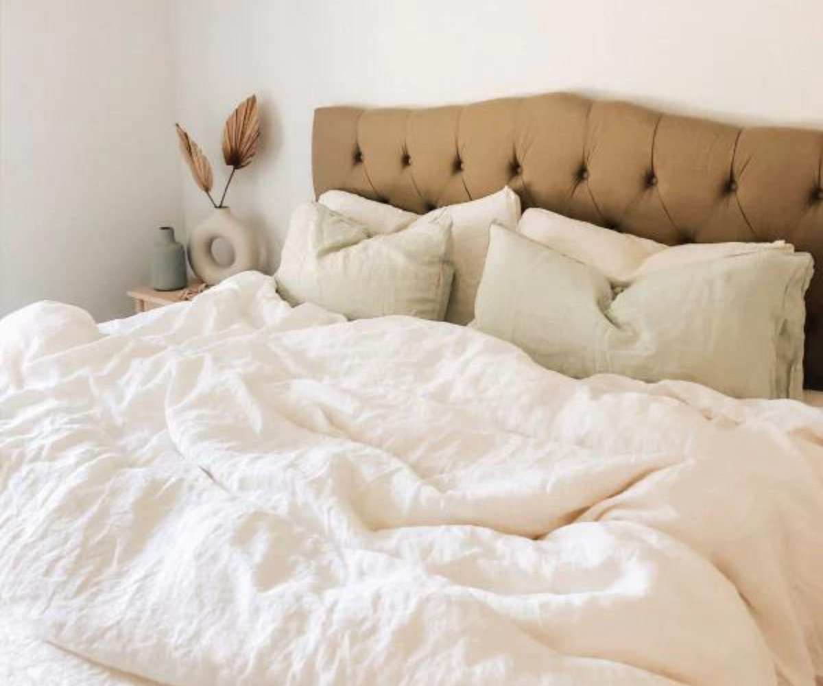 Brooklinen Down Comforter on a bed against a headboard.