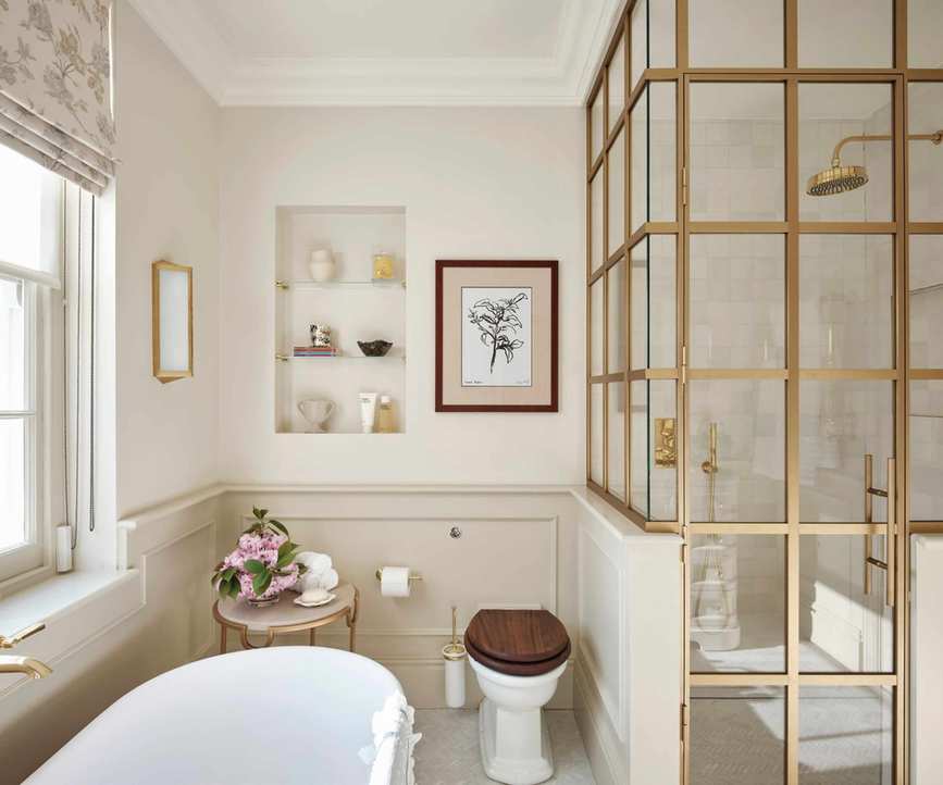 A beige guest bathroom with brass accents