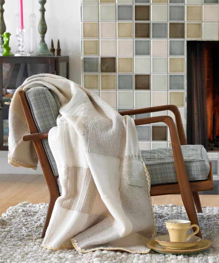 A wool sweater draped over the edge of a wooden armed arm chair