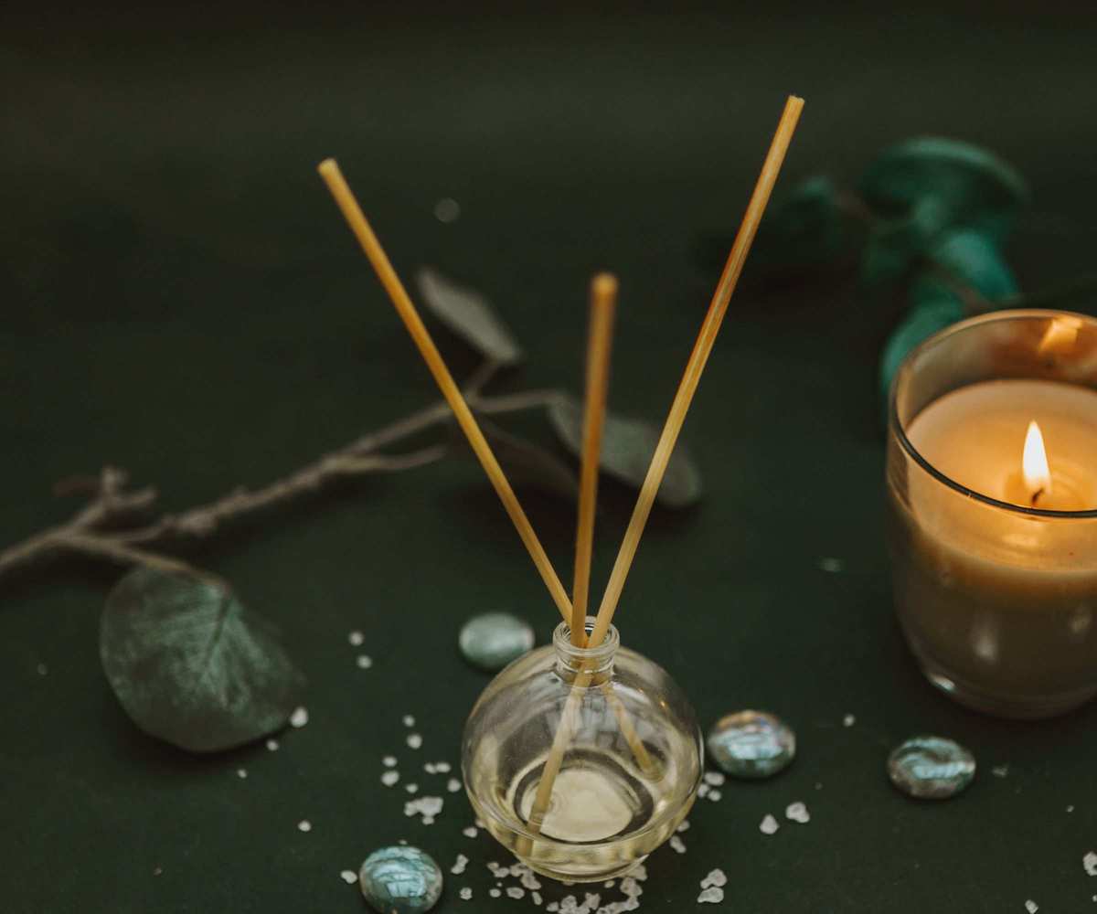 A diffuser on a table with a candle