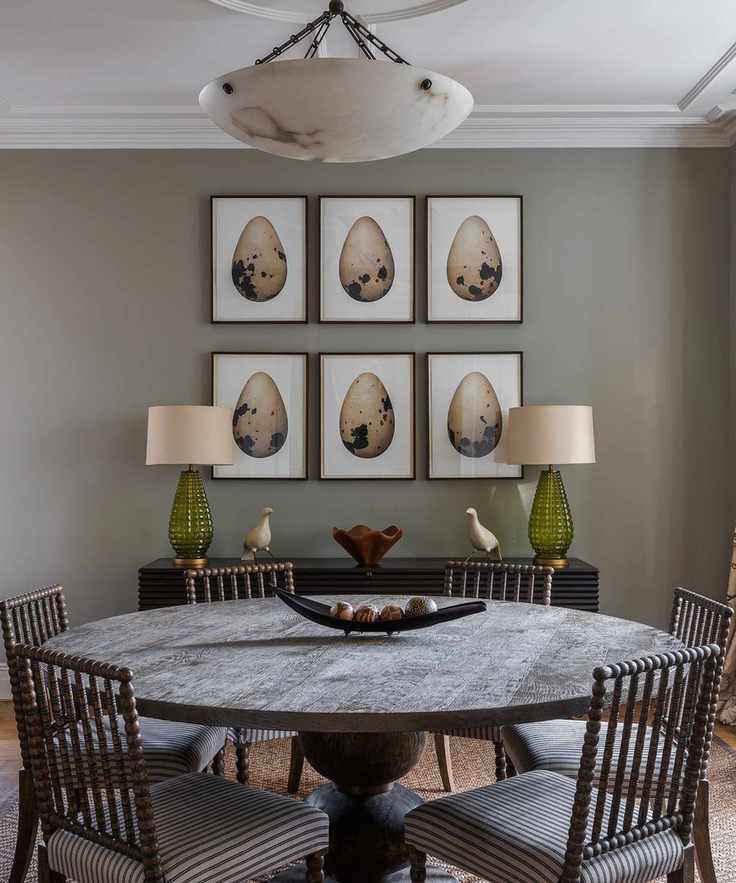 round dining table with six prints above and two lamps on sideboard
