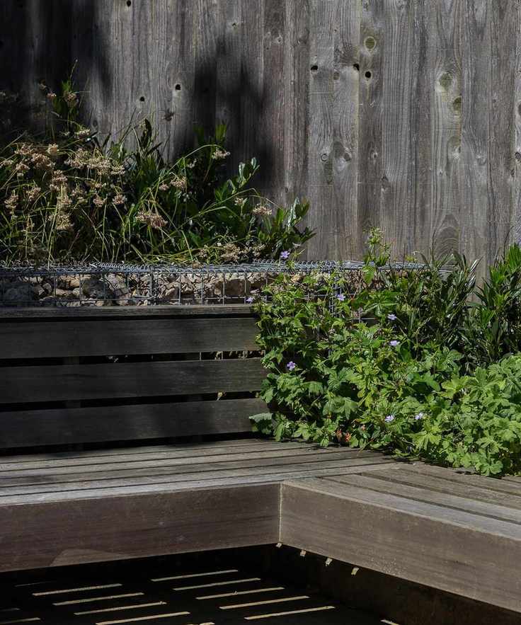 wooden seat bench and matching fence with planting in minimal garden design