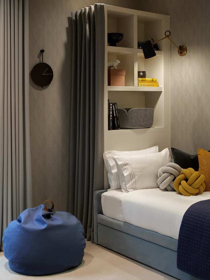 Gray and blue boy bedroom with tall storage behind bed