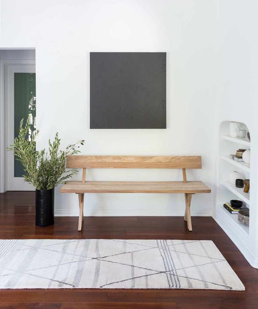 Modern entryway with white walls and wood accents
