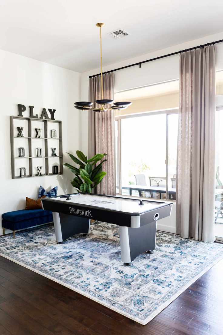 games room with air hockey table, rug, pendant lighting, noughts and crossed on the wall, plant, view out to porch