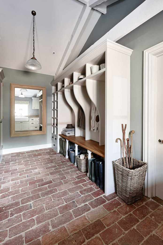 A traditional mudroom with original flooring, wicker basket storage and a long wall mirror
