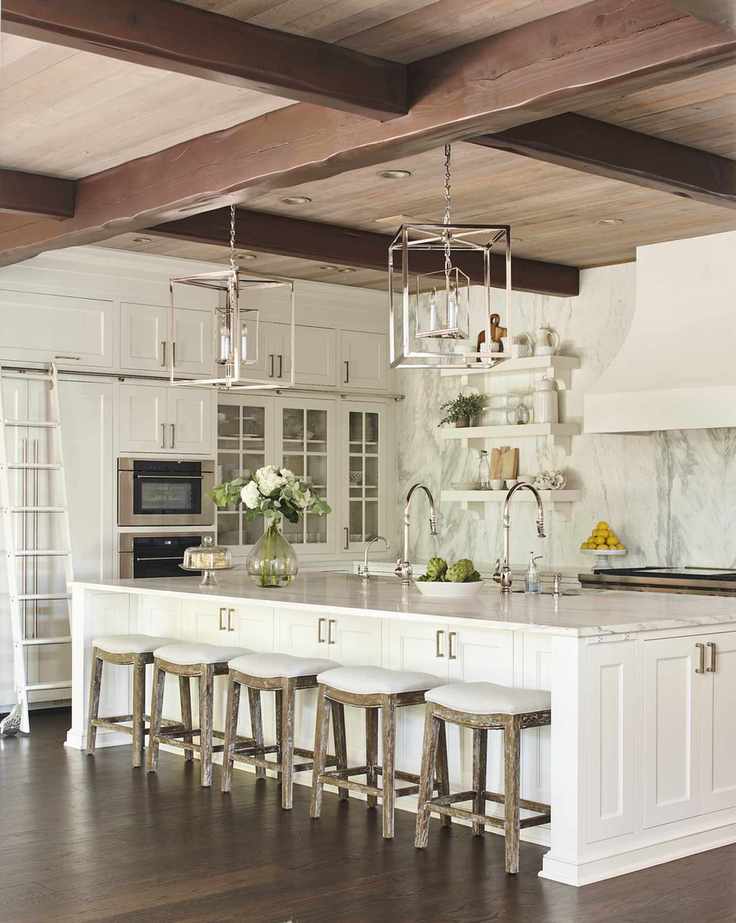 White kitchen with island, bar stools, and marble backsplash