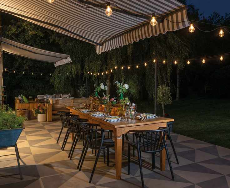 patio with awning, table and lights