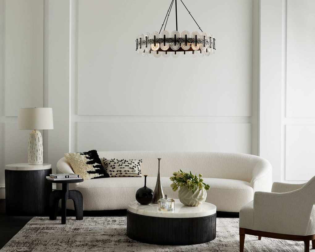 A white living room with white sofa, black coffee table and black chandelier