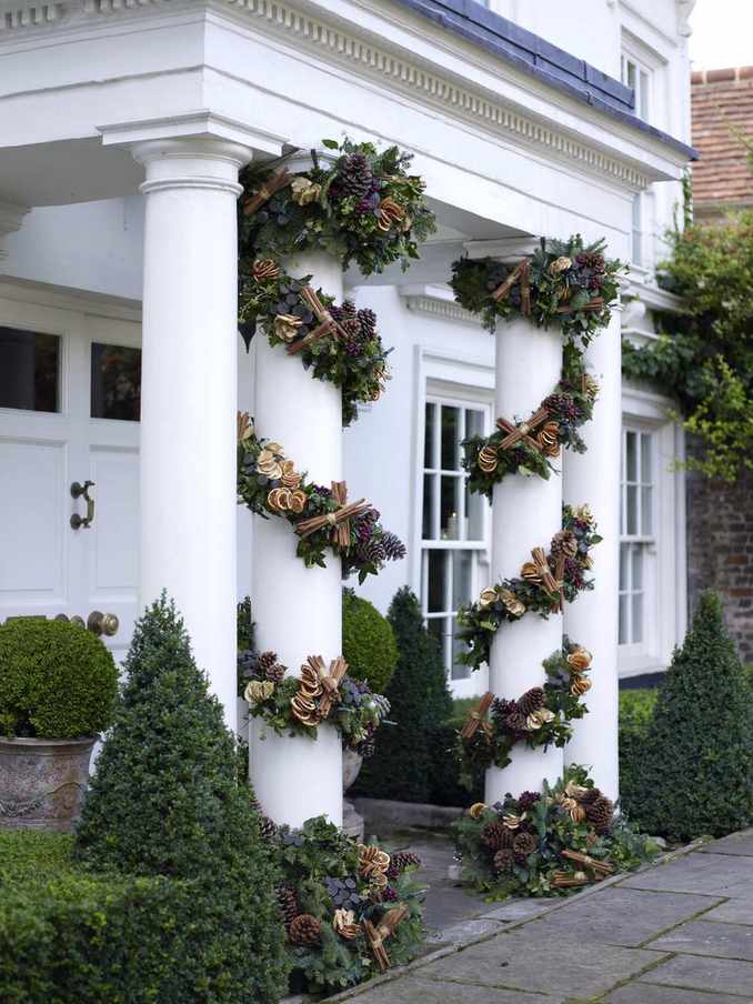 Front porch pillars wrapped in pine cone garland