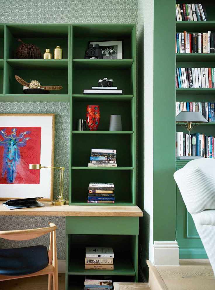 Green bookcase with art on shelves