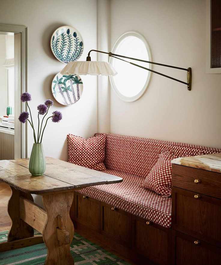 dining nook with rustic antique wooden table and upholstered bench seat