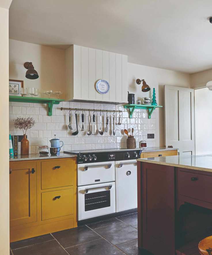 Georgian kitchen with yellow and purple cabinets and cream tiles and wall and aga