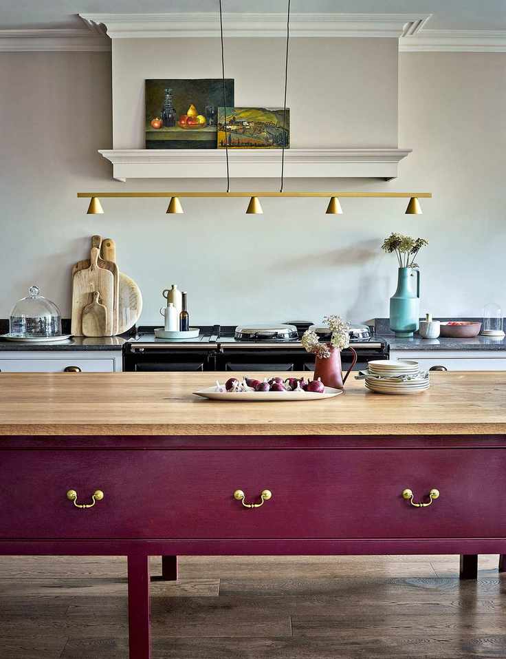 French country kitchen with painted purple island and large range with cream walls