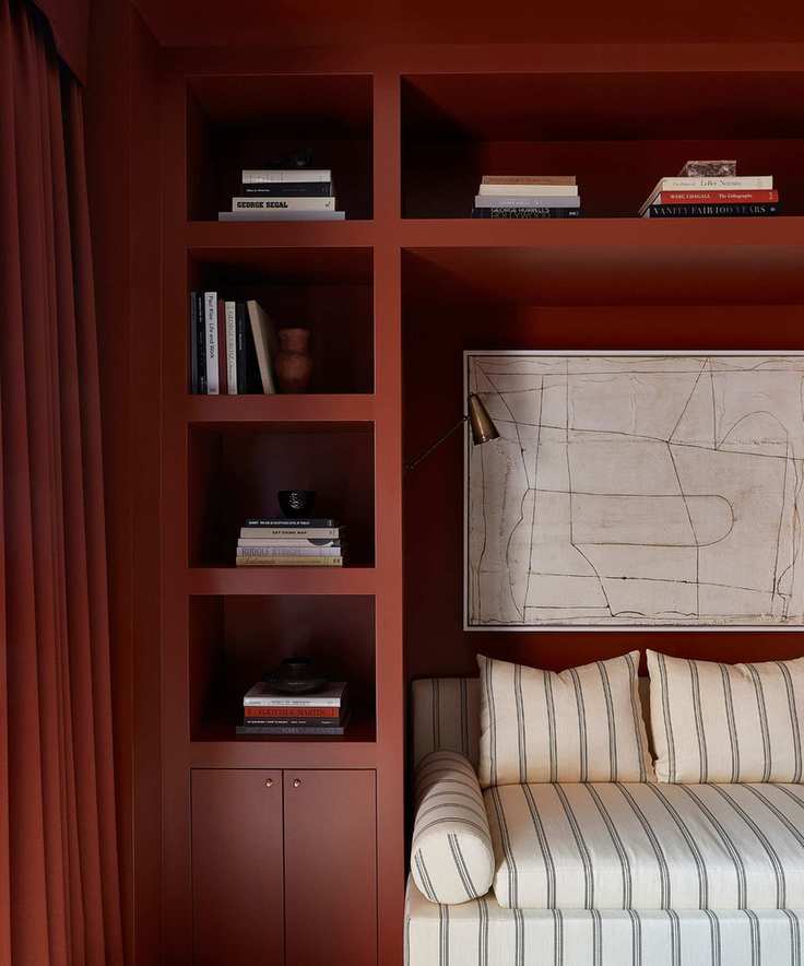 red built in nook area with shelving and a sofa