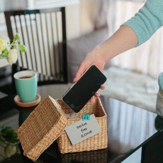Image of phone going into a box with sign that says 