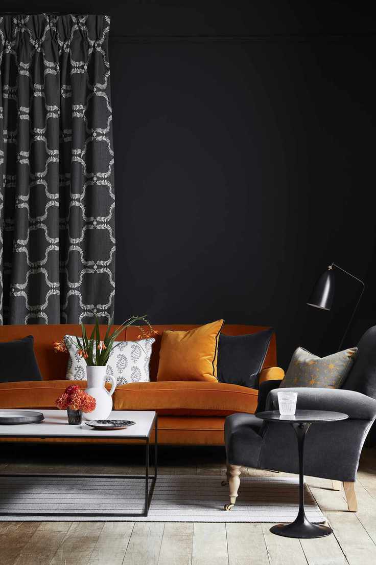 Black living room with orange velvet sofa