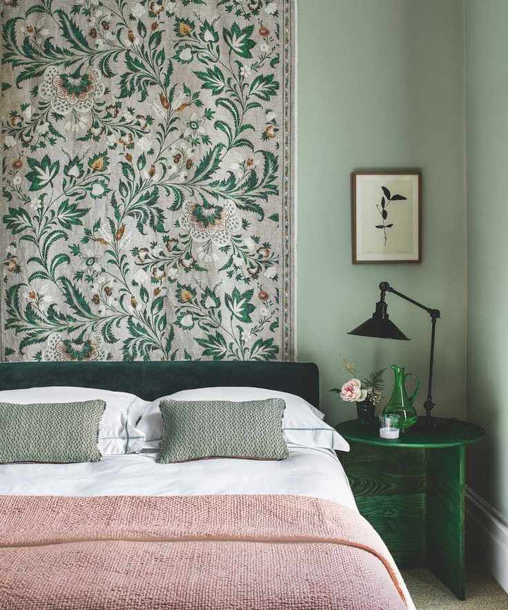 A cozy green bedroom with layered bedding