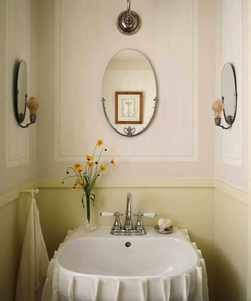 A powder room showcasing butter yellow lower walls and warm white panels.