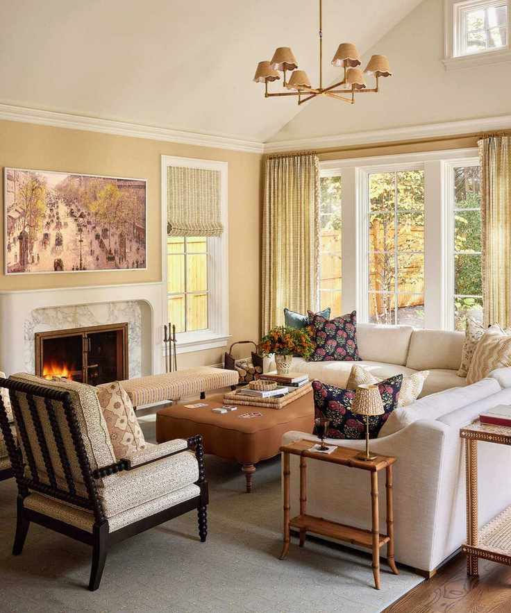 Warm living room featuring beige walls, large French doors, cream sectional, and a bobbin armchair
