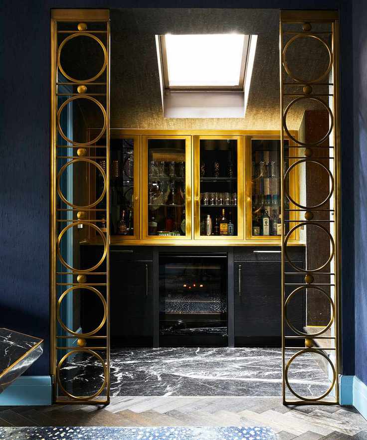 Home bar with blue walls and gold accents