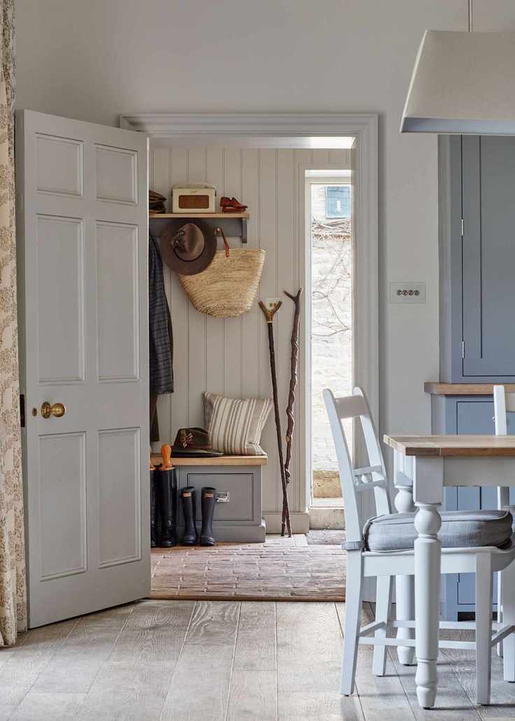 An example of mudroom ideas showing a kitchen with a dining table next to a doorway leading to a mudroom and hallway in one