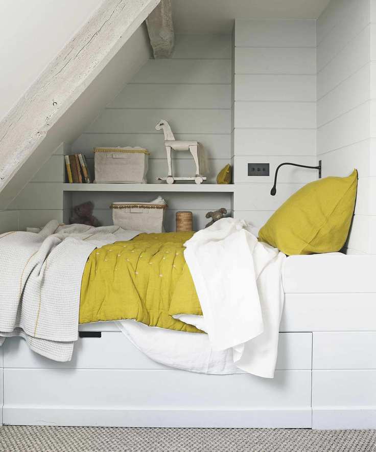 White box room ideas featuring a single bed with yellow throw and built-in storage.