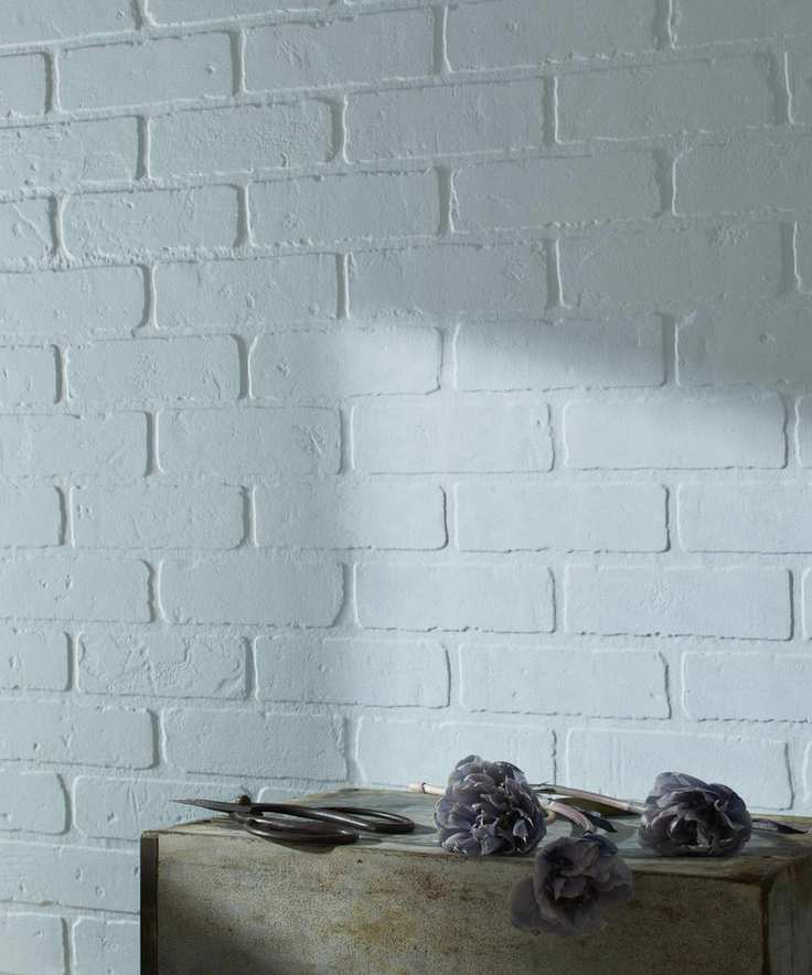 A brick wall painted in a very pale grey with a slight blue tinge