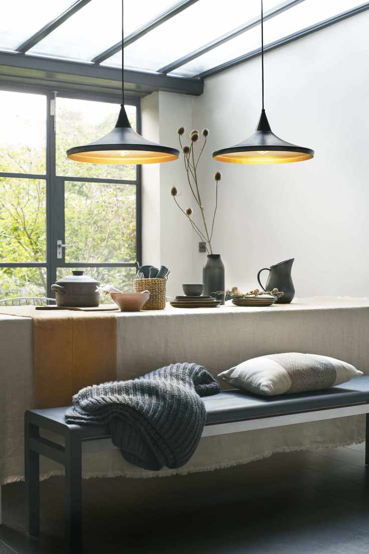 contemporary kitchen diner with pendant lights above a table and bench seating
