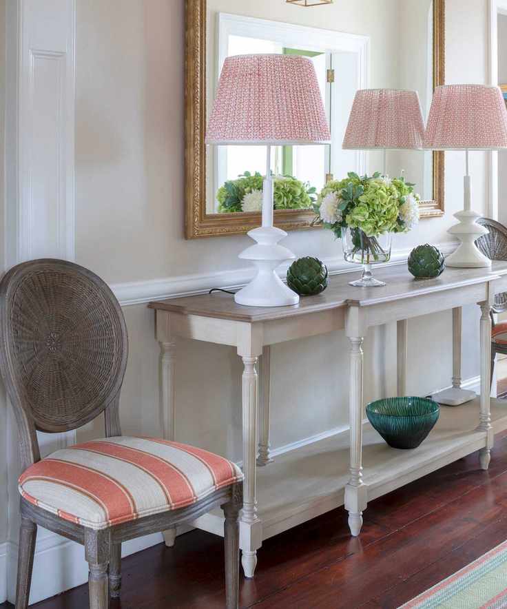 Small hallway showcasing a console table with matching lamps flanking a gilt mirror.