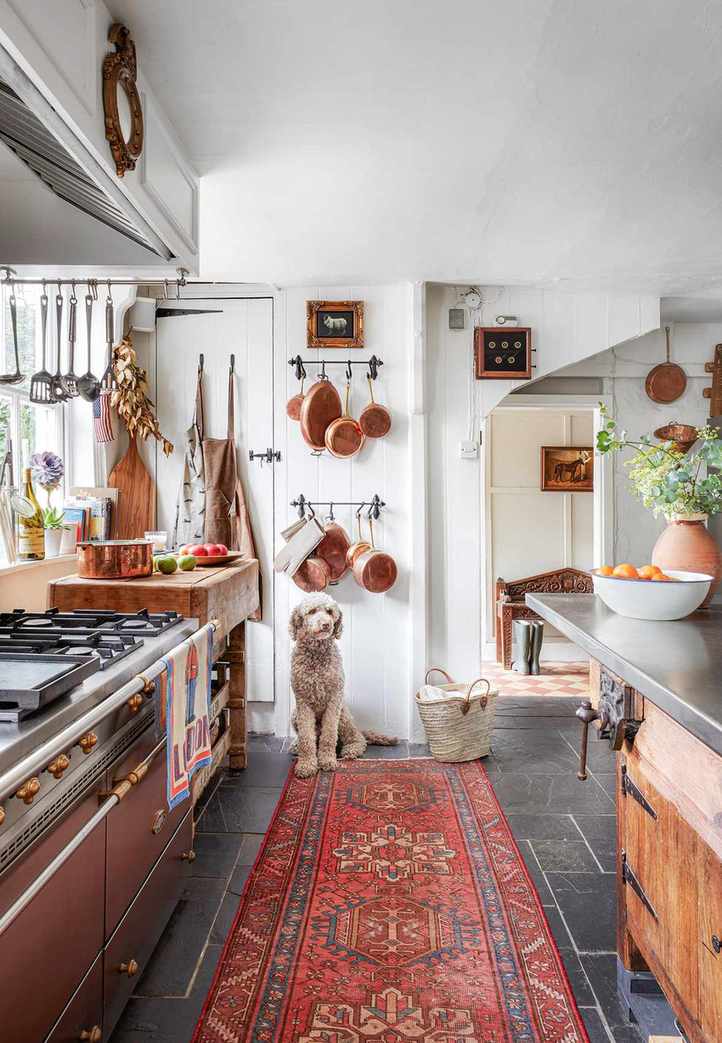 Slate floor in a rustic vintage kitchen with a red rug