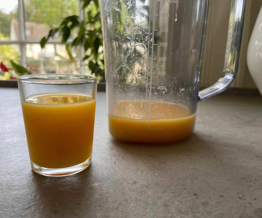 A glass of orange juice made in the Nama J3 Juicer