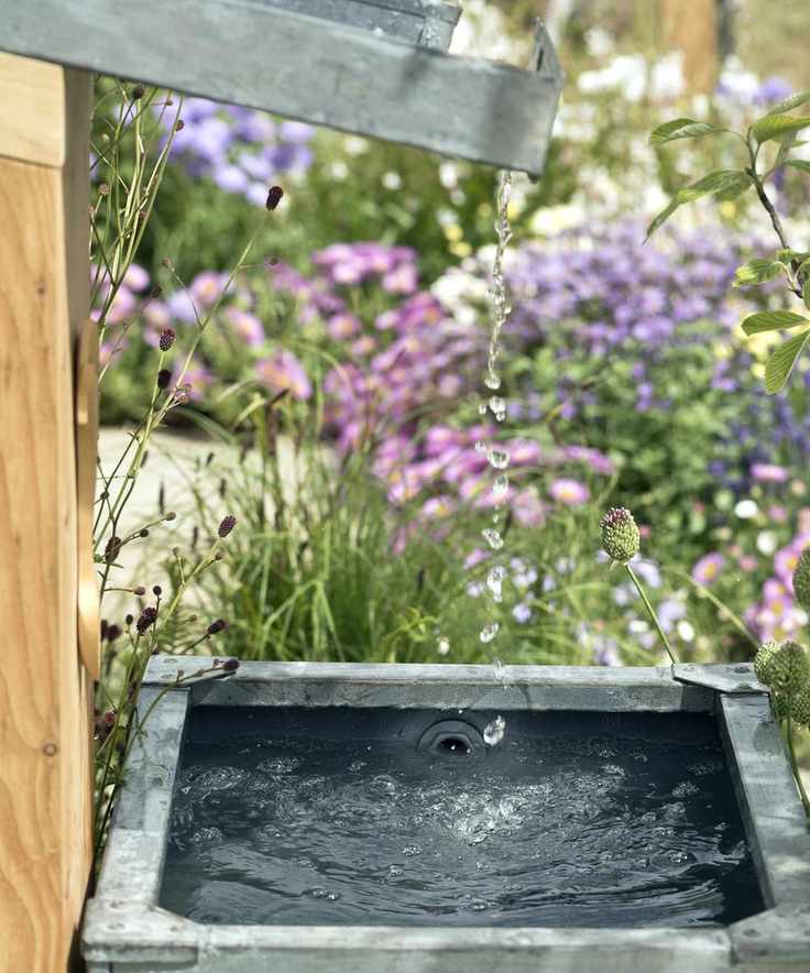 Slanted garden roof rain water run off collecting in rain barrel